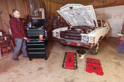 Photo of Craftsman CMST22654BK black rolling tool chest with drawers in a garage, next to a classic white car with open hood.